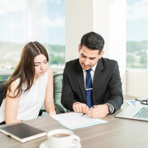 Young adviser explaining legal document to client in his office