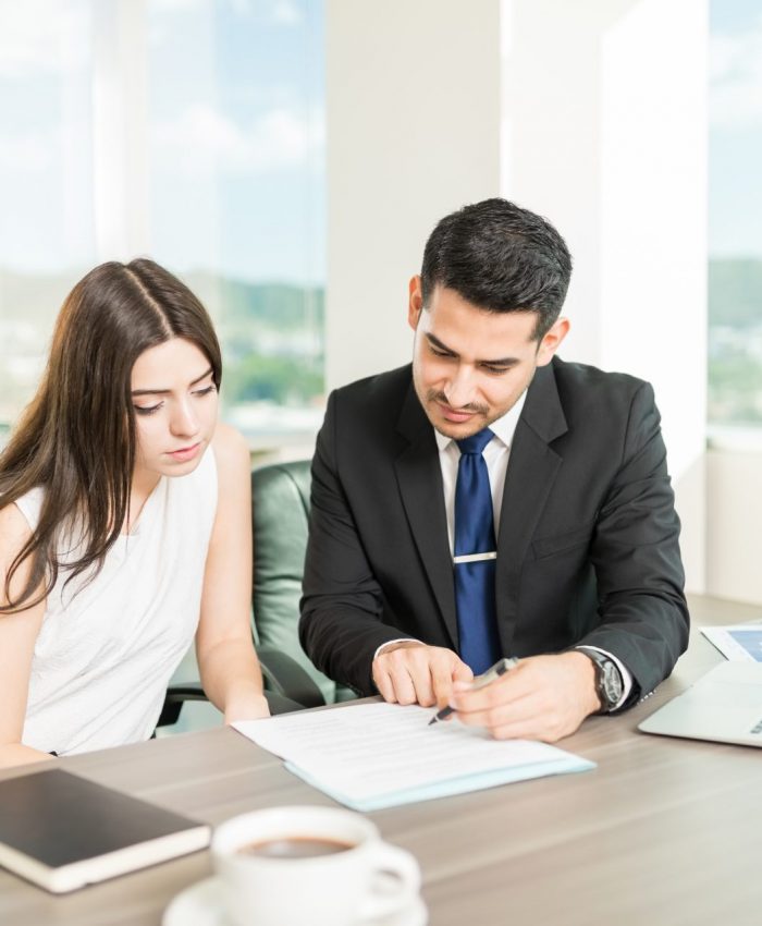 Young adviser explaining legal document to client in his office